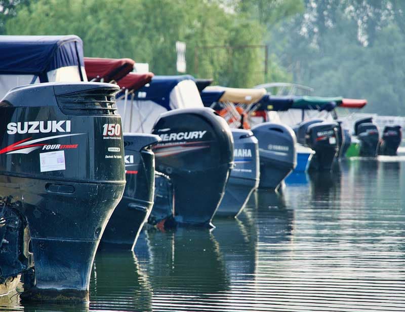 Line of outboard motors from several major brands on the water